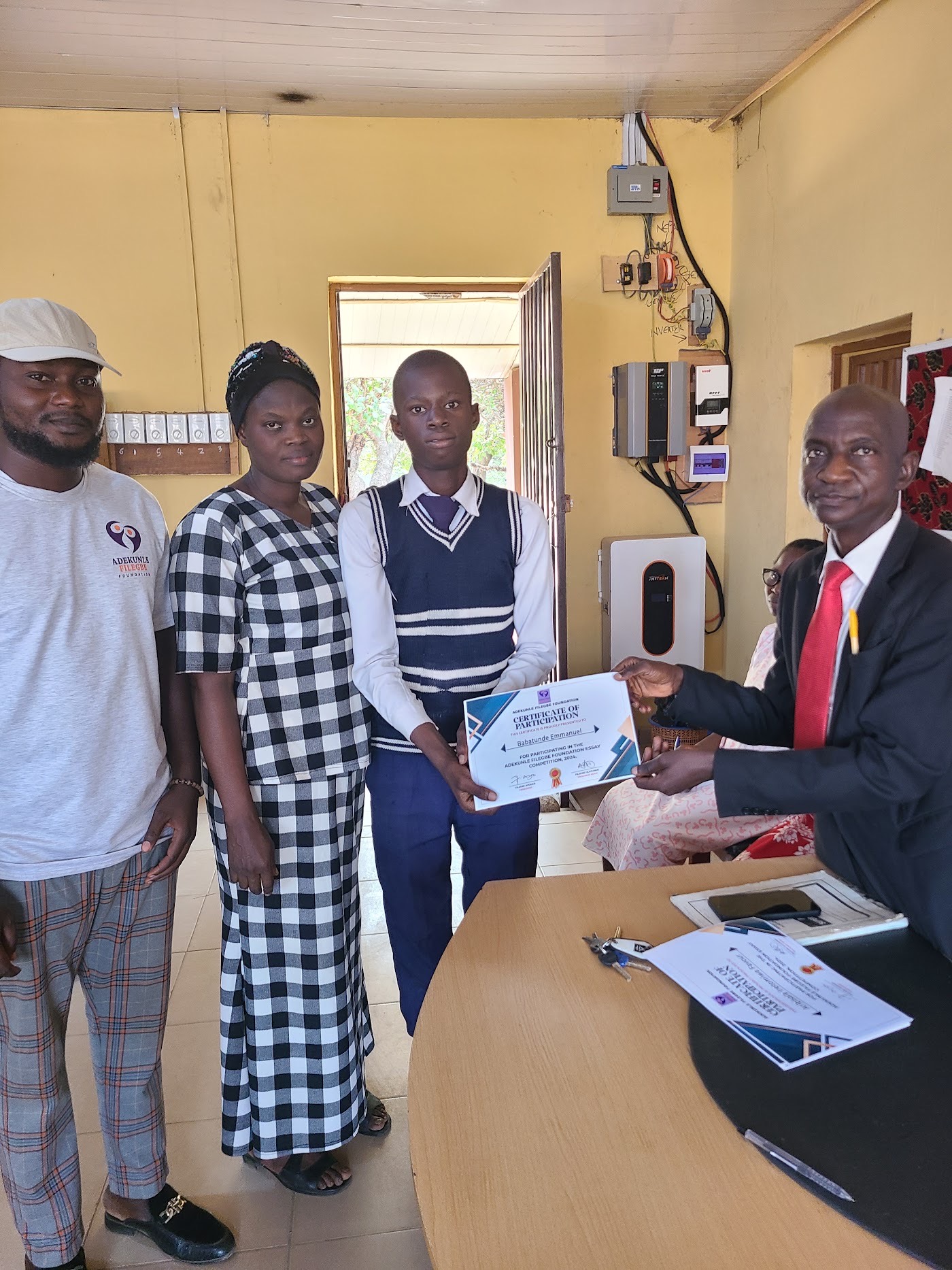 A student receiving a certificate at a school science bench.